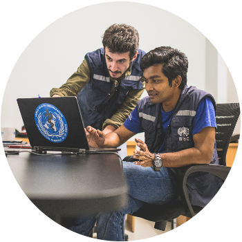 Two male WHO staff looking at a computer.