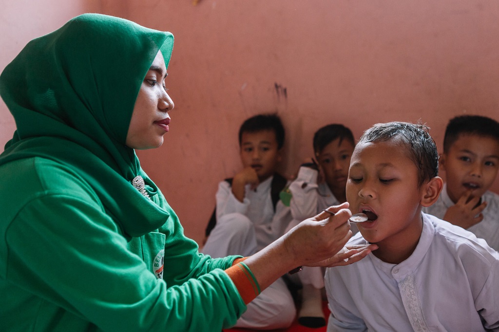 A child receives a dose of medication during a mass drug administration for the elimination of lymphatic filariasis in South Sumatra.
