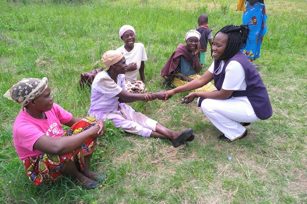 Nurse Carole saluting women during a community outreach, Zambia