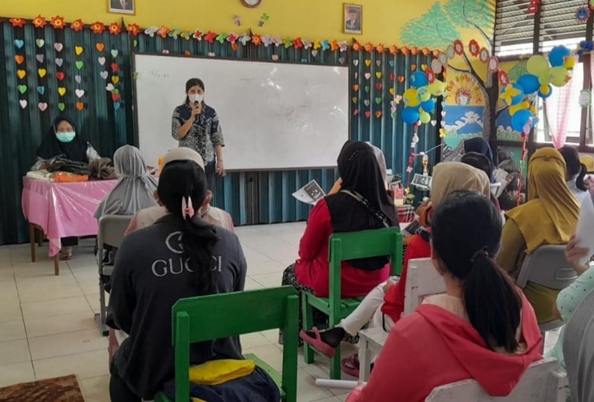 Healthcare workers in front of a class, convincing parents to get their children immunized.
