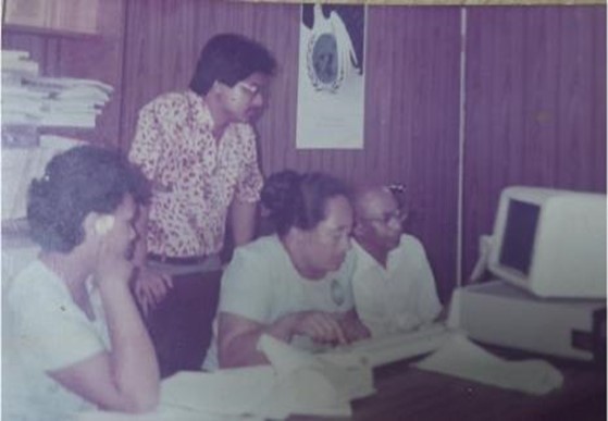 WHO Samoa staff work together in front of a computer